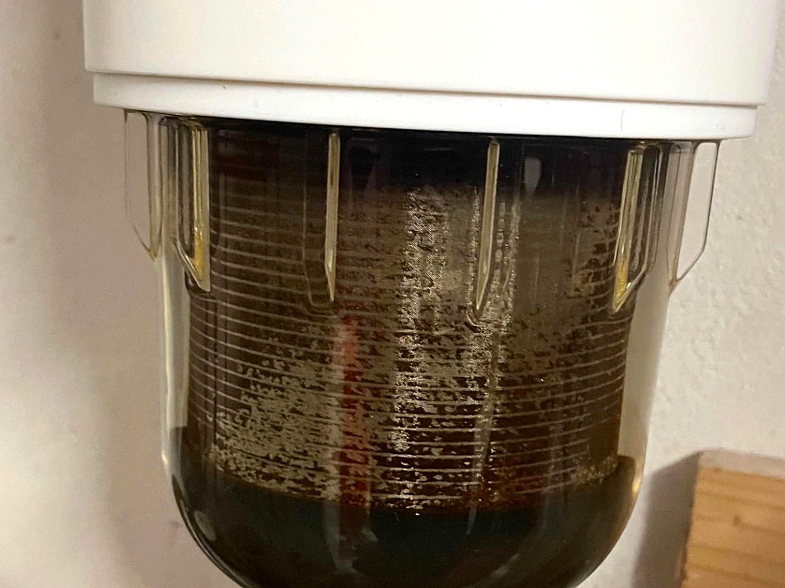 Stark verschmutzter Trinkwasserfilter mit dunklen Ablagerungen vor dem Wechsel