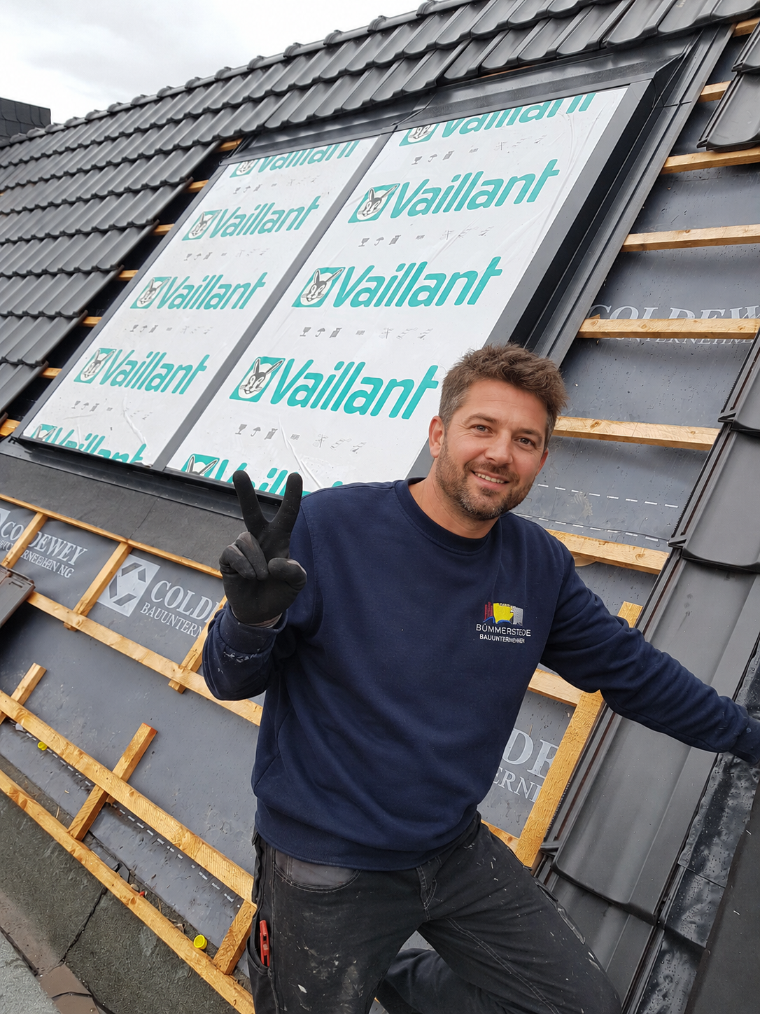 Monteur im BÜMMERSTEDE-Arbeitsshirt bei der Kollektormontage auf einem Dach in Dangast