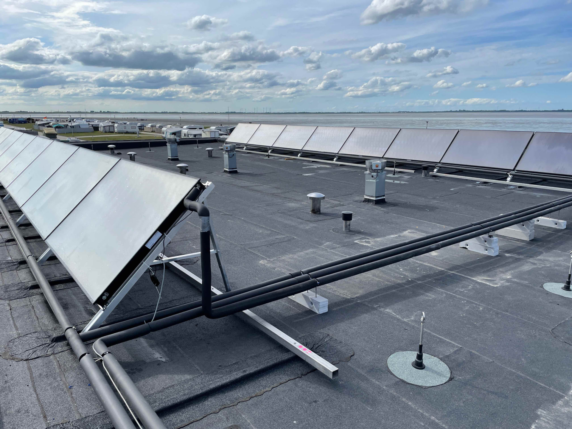 Solarthermie-Großanlage auf dem Flachdach eines Campingplatzes an der Nordseeküste mit gedämmter Verrohrung