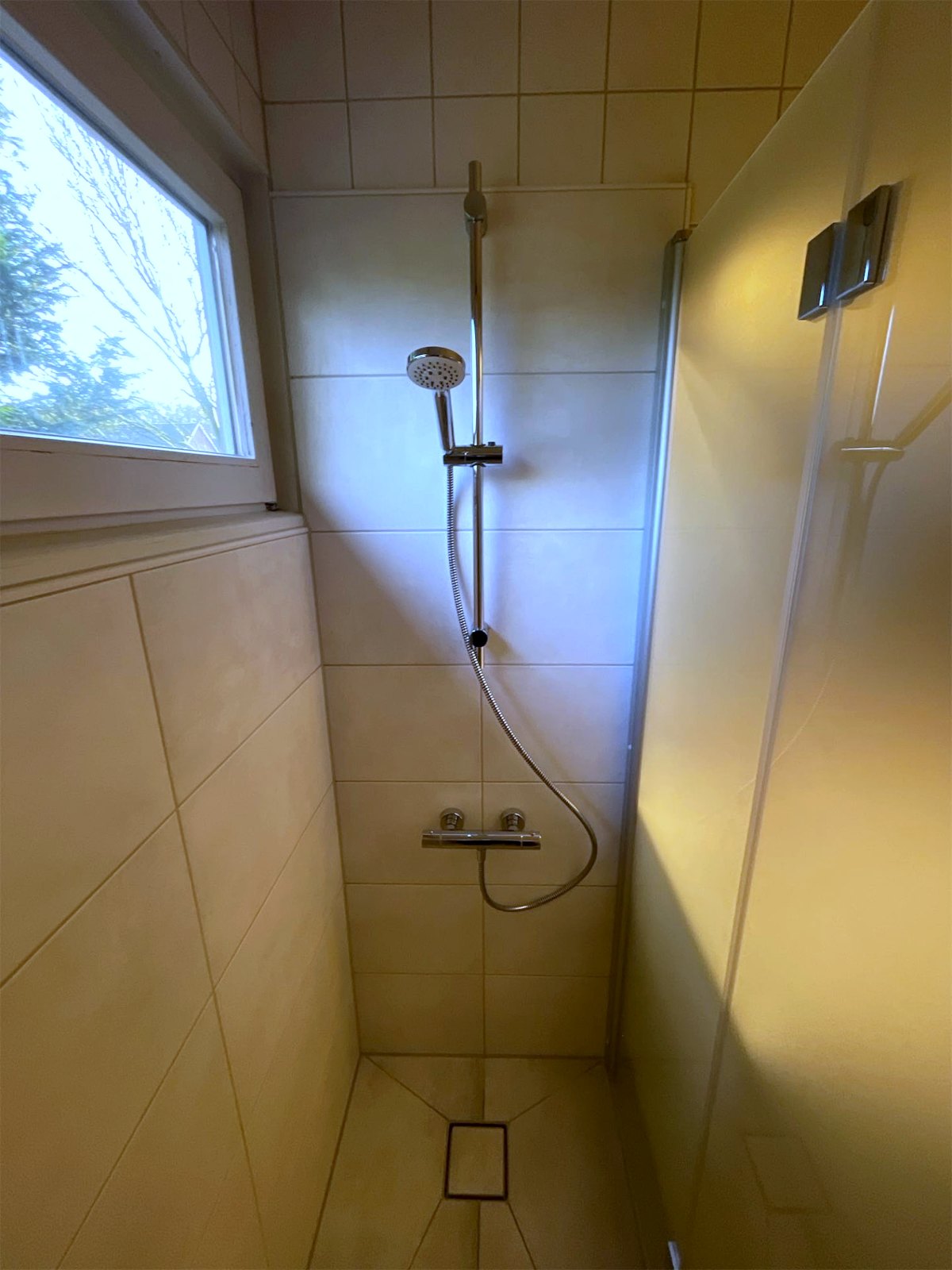 Neuer bodengleicher Duschplatz mit Punktablauf, Thermostatarmatur und Glastür an der Stelle der früheren Badewanne